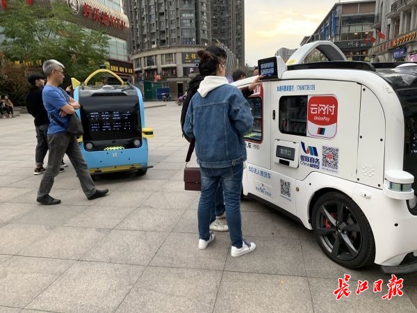 5G无人售货车在街头，吸引了不少年轻人的“尝鲜”。记者尹勤兵 摄